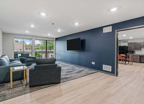 a living room with blue walls and a tv on the wall