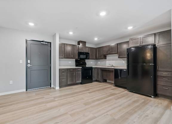 a kitchen with black appliances and dark wood cabinets
