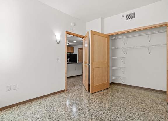 A kitchen with a wooden door and a tiled floor.