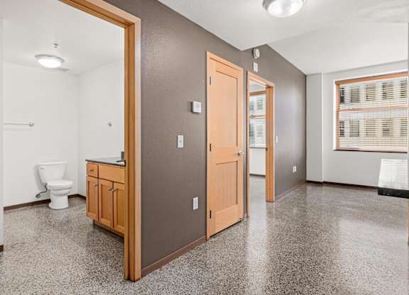 A bathroom with a toilet, sink, and a mirror.