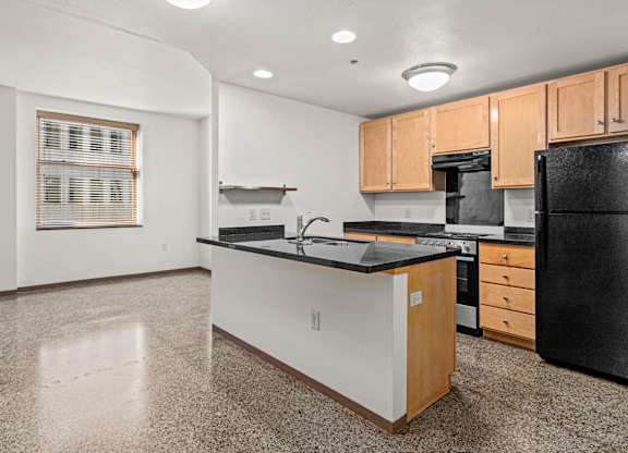 A kitchen with black and white appliances and wooden cabinets.
