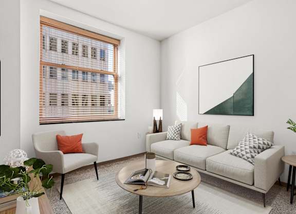 A living room with a couch, chair, and a painting on the wall.
