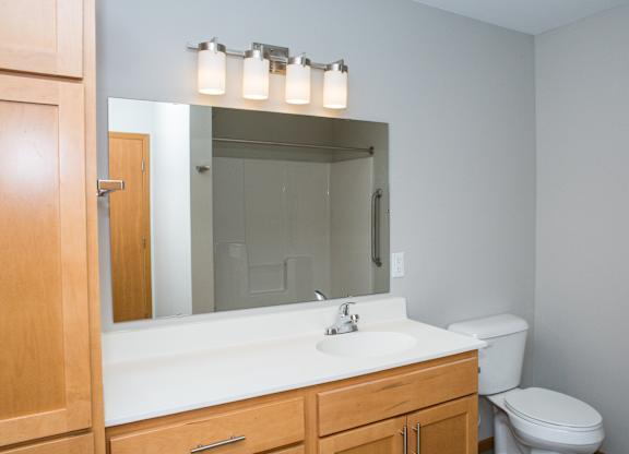 A bathroom with a white sink and a mirror above it.