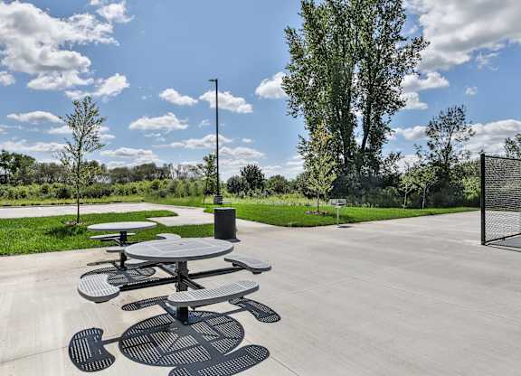 A picnic table is in the middle of a paved area.
