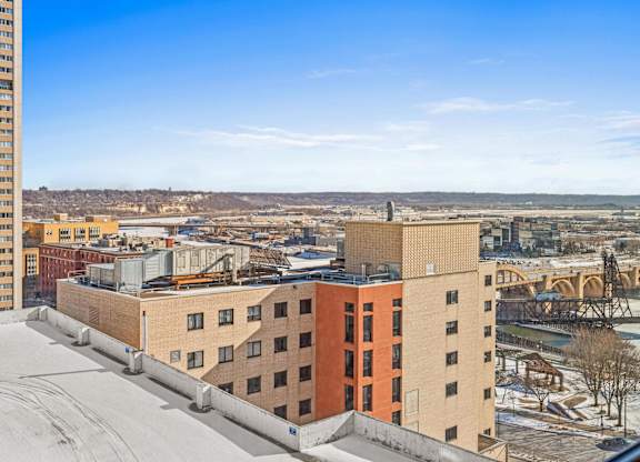 A view from a high-rise building looking out over a cityscape with a river and a bridge.