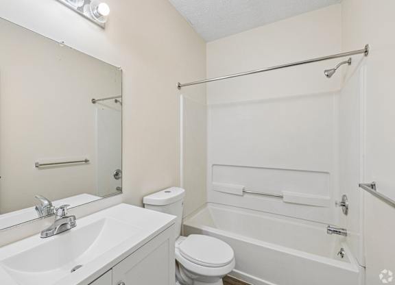 A white bathroom with a sink, toilet, and bathtub.