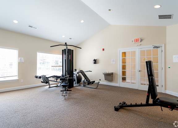 A gym with a rowing machine, a treadmill, and a stationary bike.