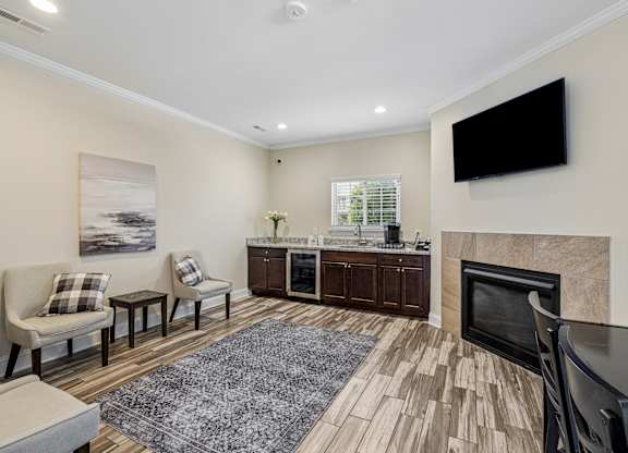 A living room with a fireplace and a television mounted on the wall.