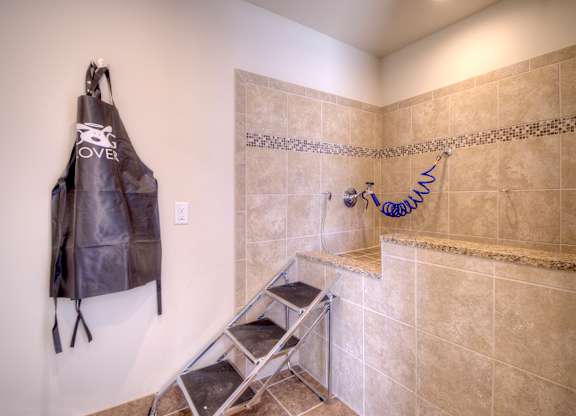 A bathroom with a brown leather jacket hanging on the wall.
