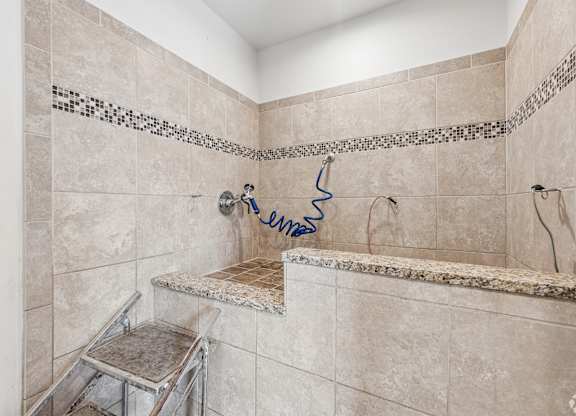 A bathroom with a shower and a bench seat.