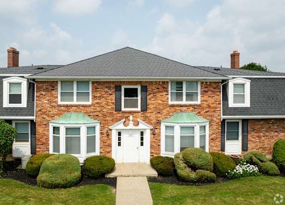 A brick house with a white door and windows.