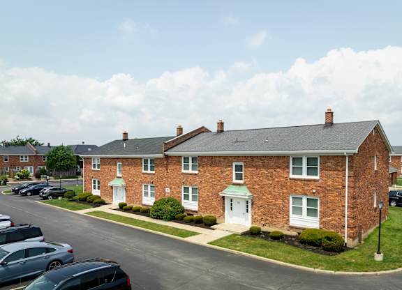 A brick house with a green lawn in front.