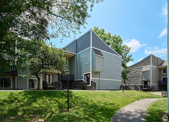 A modern house with a triangular roof and a balcony.