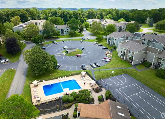 A bird's eye view of a residential area with a swimming pool and tennis court.