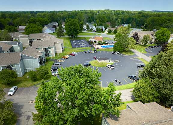 A parking lot with cars and apartment buildings in the background.