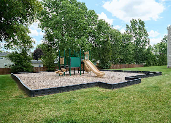 A playground with a green slide and a yellow slide.