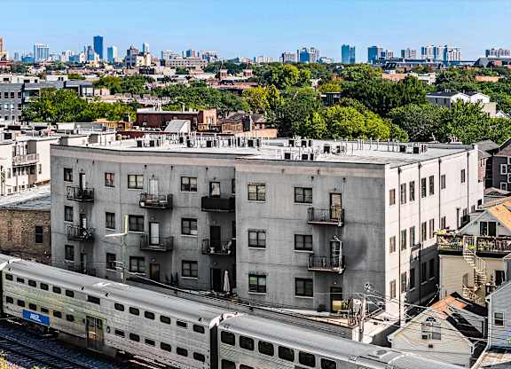 A train is passing by a building.