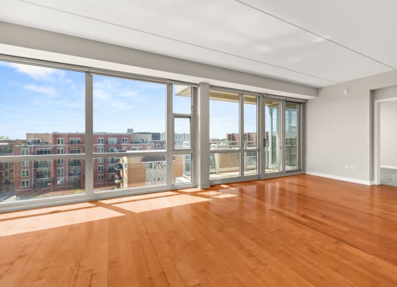 a living room with wood floors and a balcony overlooking a city