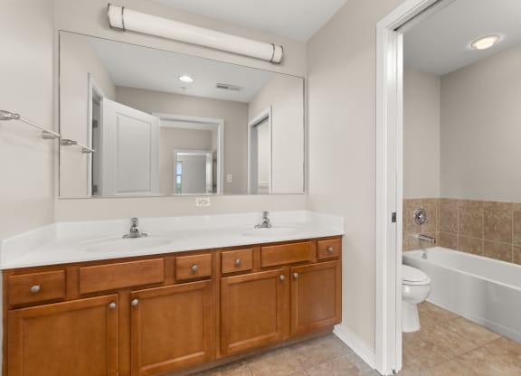 a bathroom with a large mirror and a sink and a toilet