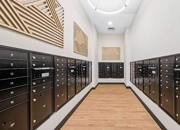 A long hallway with black mailboxes on either side.