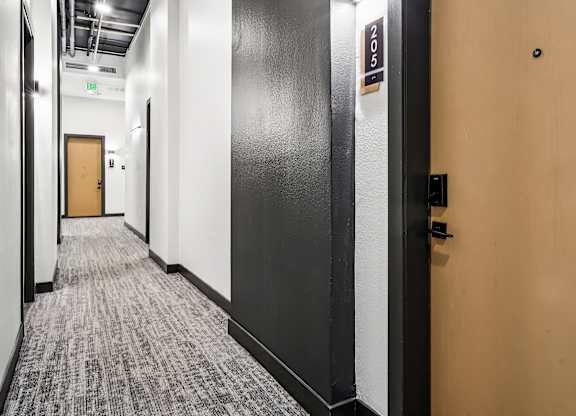 A hallway with a door on the right and a sign on the wall.