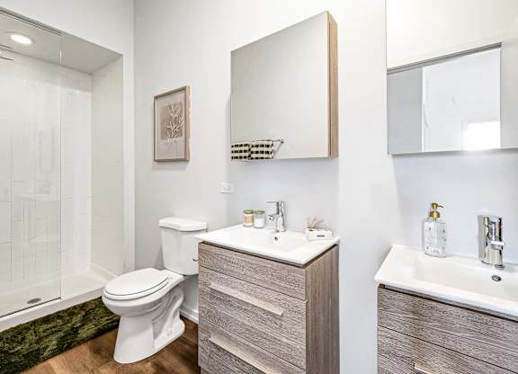 A bathroom with a toilet, sink, and shower.