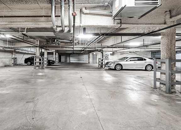 A car is parked in a large, empty parking garage.