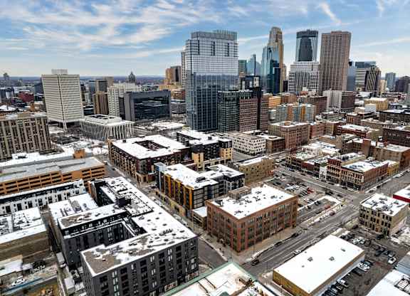 A cityscape with buildings and snow on the ground.