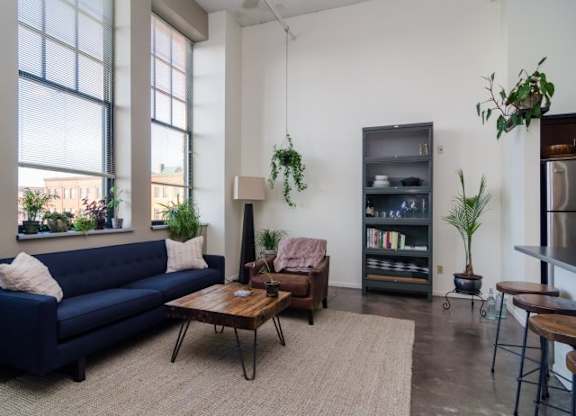 A living room with a blue couch, a wooden coffee table, and a bookshelf.