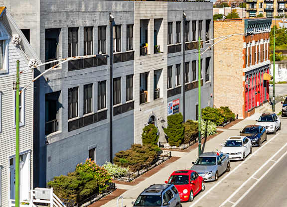 A street view of a city with cars parked on the side of the road.