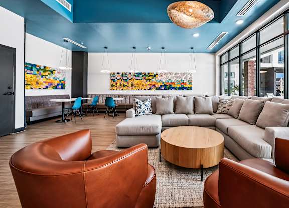 A living room with a brown leather chair and a grey sofa.