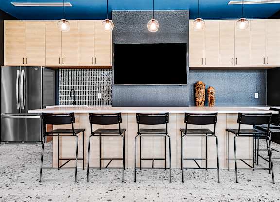 A kitchen with a bar area featuring a counter and chairs.