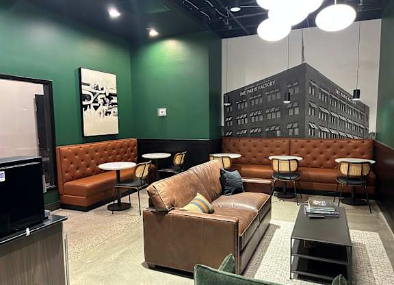 A room with green walls and a brown couch.