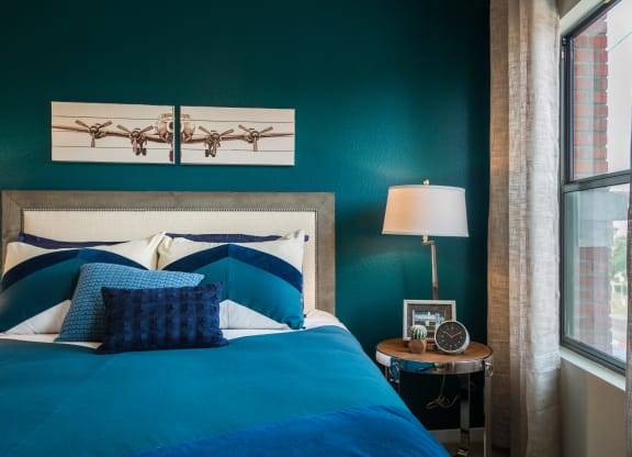 Bedroom With Bed And Side Table With Large Window At Union at Roosevelt Apartments In Phoenix, AZ