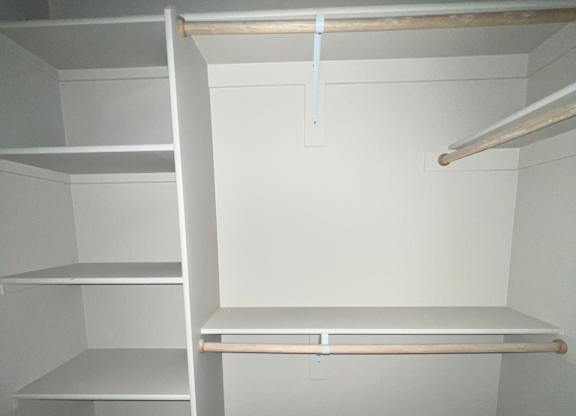 a small closet with a window in a white room