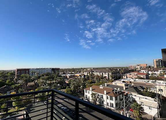 a balcony with a view of the city and palm trees