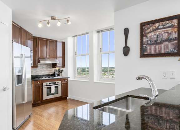 A kitchen with a granite counter top and a painting hanging on the wall at Residences Providence, Providence, Rhode Island