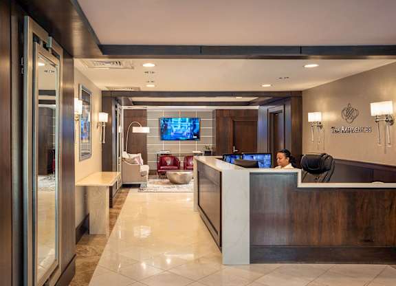 A reception area with a woman sitting behind the desk at Residences Providence, Providence, RI 2903