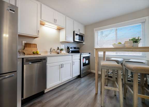 Large white kitchen with stainless steel appliances and wide window at 151 Ocean Road LLC, Rhode