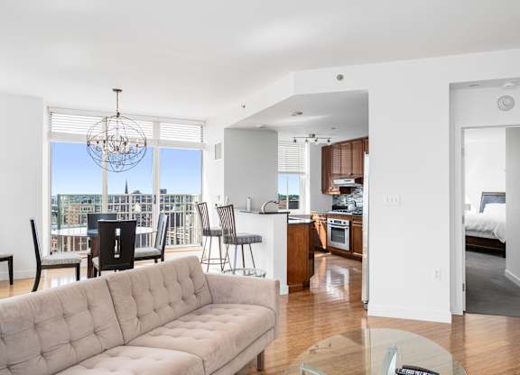 A living room with a couch, chairs, and a dining table at Residences Providence, Providence, RI