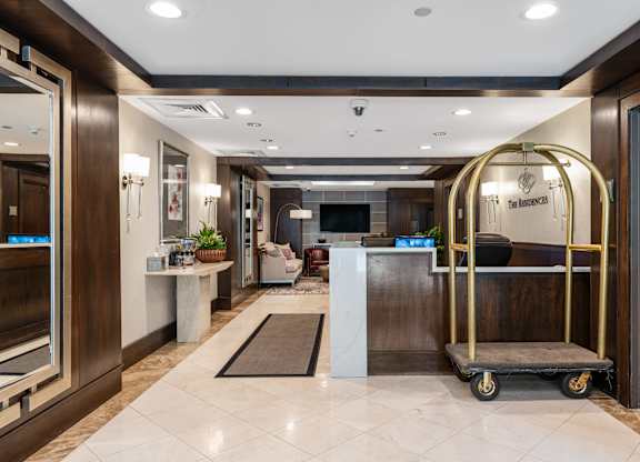 A hotel lobby with a white marble floor and a black and gold cart at Residences Providence, Providence, Rhode Island