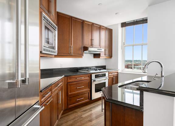 A modern kitchen with wooden cabinets and stainless steel appliances at Residences Providence, Rhode Island
