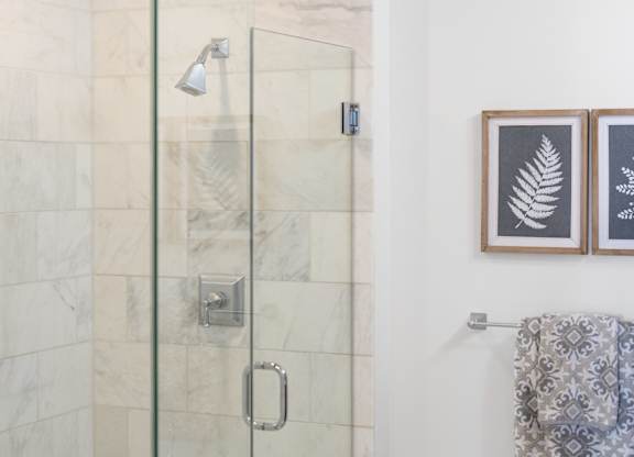 A bathroom with a glass shower stall and a towel hanging on the wall at Residences Providence, Rhode Island 2903
