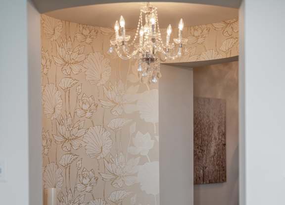 A hallway with a chandelier and wallpapered walls at Residences Providence, Providence, RI 2903