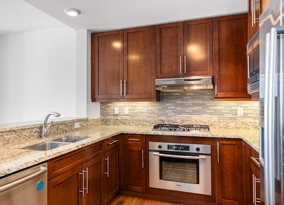 A kitchen with wooden cabinets and a granite countertop at Residences Providence, Providence, Rhode Island