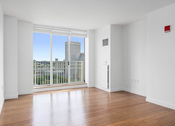 A room with a view of a city skyline through a large window at Residences Providence, Rhode Island