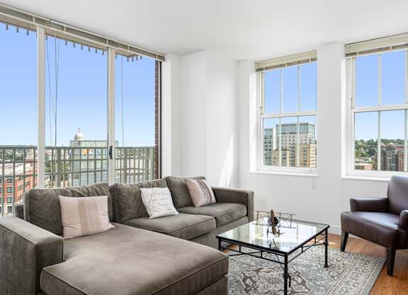 A living room with a grey couch, a glass table and a chair at Residences Providence, Providence, 2903