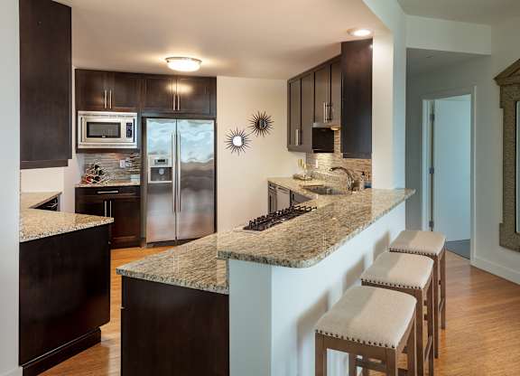 A kitchen with a granite counter top and stainless steel appliances at Residences Providence, Providence, 2903