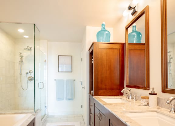 A bathroom with a glass shower stall and a white bathtub at Residences Providence, Providence, RI 2903