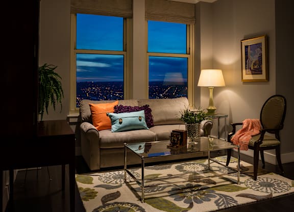 A living room with a couch, a chair, a coffee table, and a lamp at Residences Providence, Providence, Rhode Island